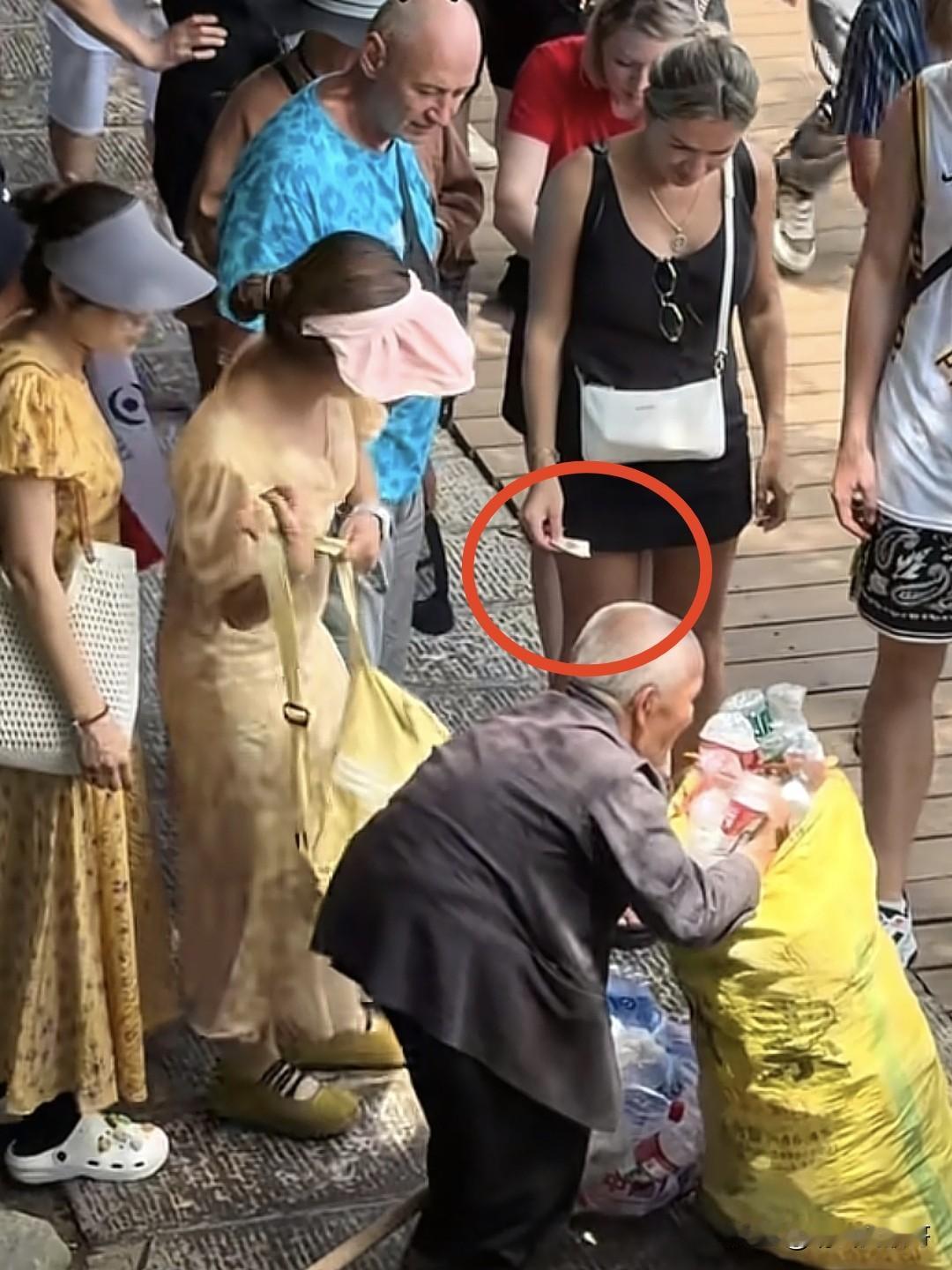 某景区一群外国游客给拾荒老人捐款，很多人都在埋怨把这个视频发到网上的人，他们说也