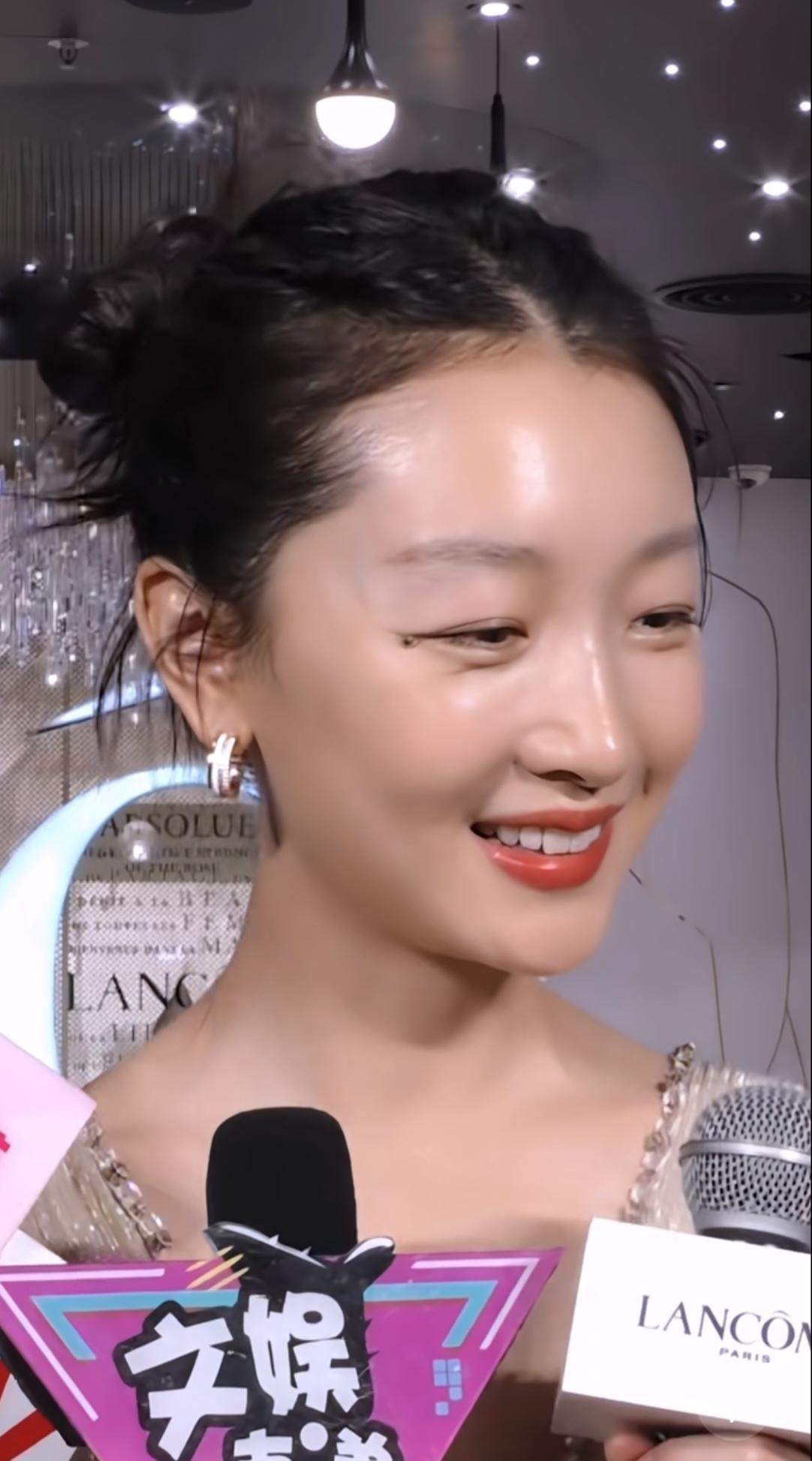 周冬雨笑起来眉眼弯弯，皮肤像剥了壳的鸡蛋细腻光滑，有少女般的元气灵动，也有成熟女