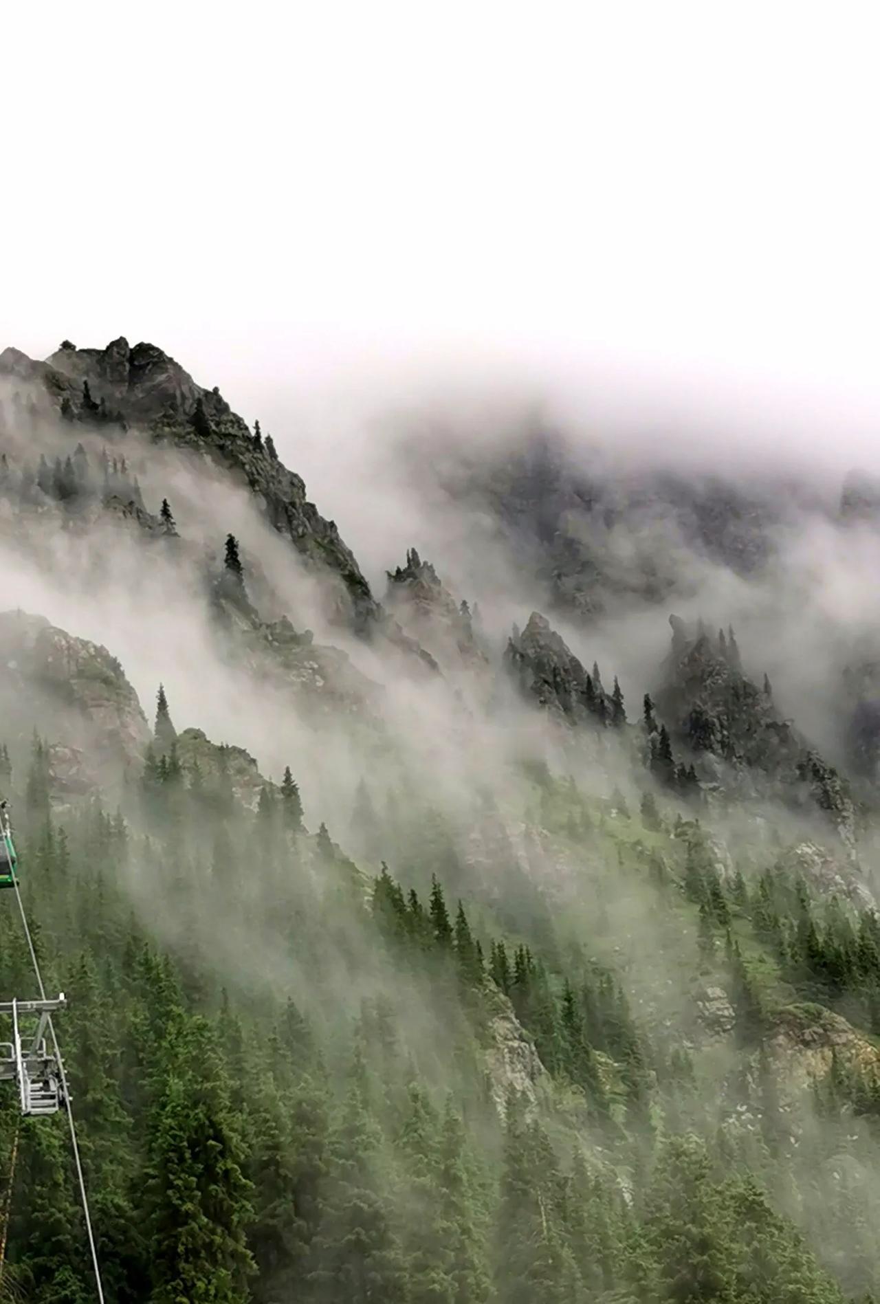 发一张站在高山上拍的图片云雾缭绕的新疆天山。