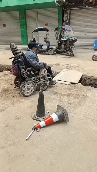 一位大爷驾驶电动轮椅过沟渠。原本以为他会很顺利的驶过沟渠。结果他却突然转了弯