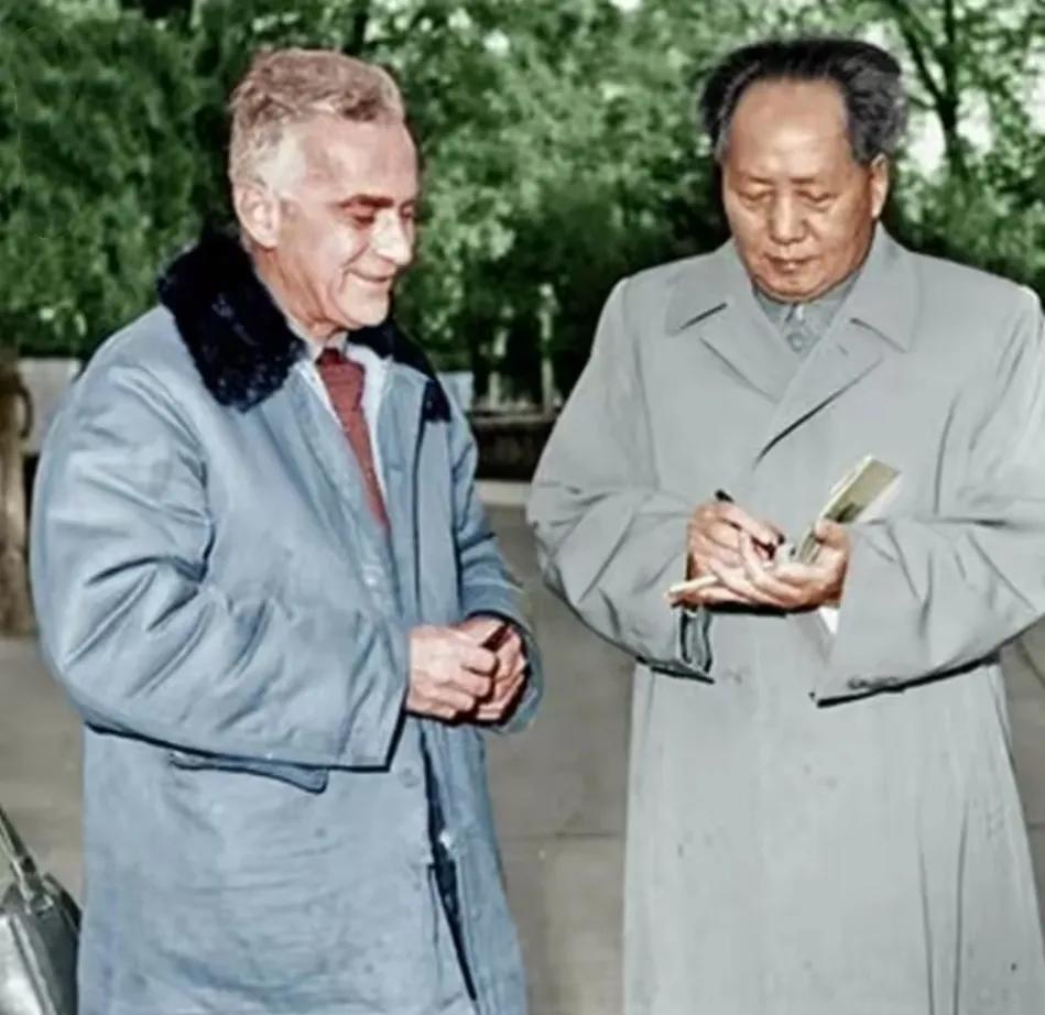 斯诺拿着笔帽，正在让毛主席帮他签字，他可是我们的老朋友了！斯诺的这身穿着很朴实，