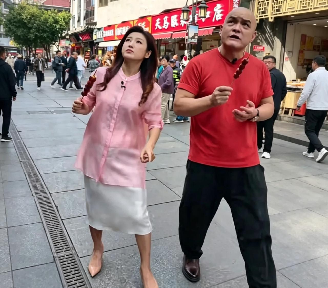 前门大街溜达，碰见春妮和史国良了。俩人举着糖葫芦边走边吃，史老师那光头红T恤，老
