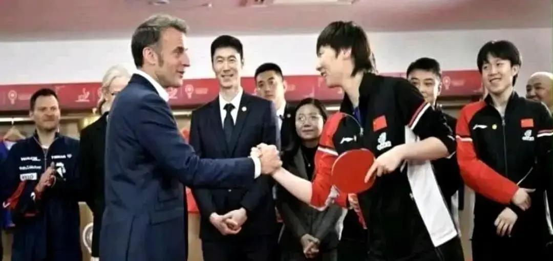 王曼昱伸手的瞬间，马克龙悄悄调整了站姿。这可不是训练好的礼仪姿势。你