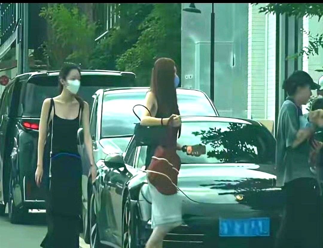 窦靖童抱着爱犬走在前面，李嫣和宋妍霏在后面边走边聊。李嫣穿了件黑色吊带长裙，紧紧跟在姐姐身后。旁边同