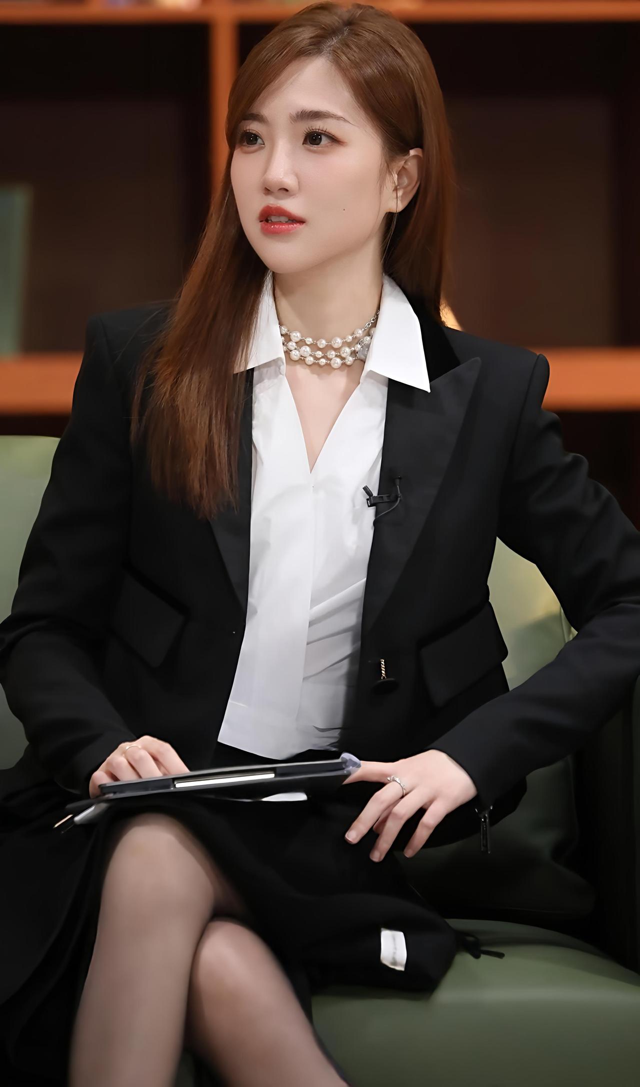 张纯烨身穿黑色西装搭配白色衬衫，配丝袜和美腿，既帅气又迷人。