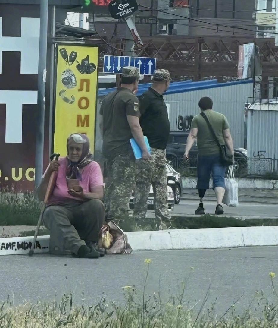 这就是乌克兰的现状，乌克兰街上看到一幕真的让人心酸。一位大妈蹲在路边乞讨，眼神空