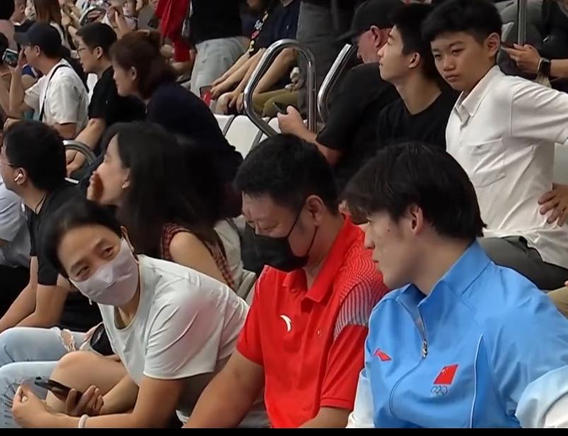 张展硕的父母也来见证儿子在亚运会的第七金了，夫妻俩很低调，戴着口罩坐在观众席，和