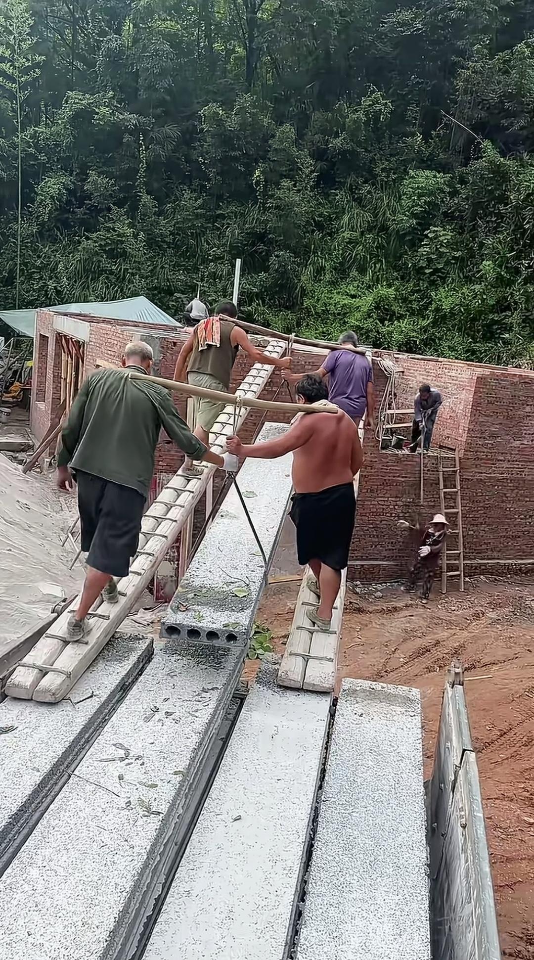 农村又现人力抬预制板架楼面的场景，暗藏的安全隐患着实不能忽视！工人们踩在长长的