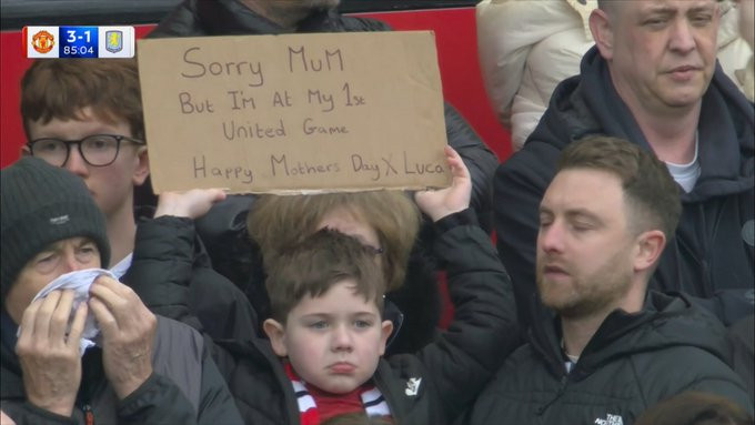 镜头拍到现场一名小球迷举得牌子上面写着对不起妈妈。这是我第一次主场观看曼联比赛母