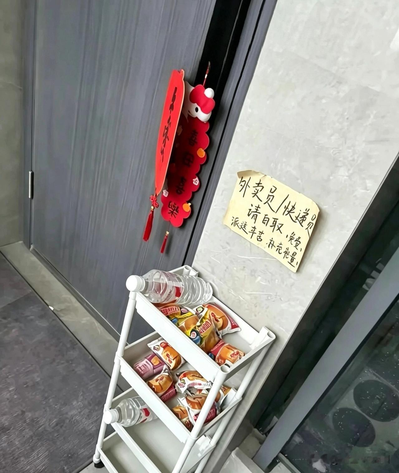 穿行街巷送单时，撞见一幕暖心的风景。有位住户在门前摆好了矿泉水和点心，专门留给