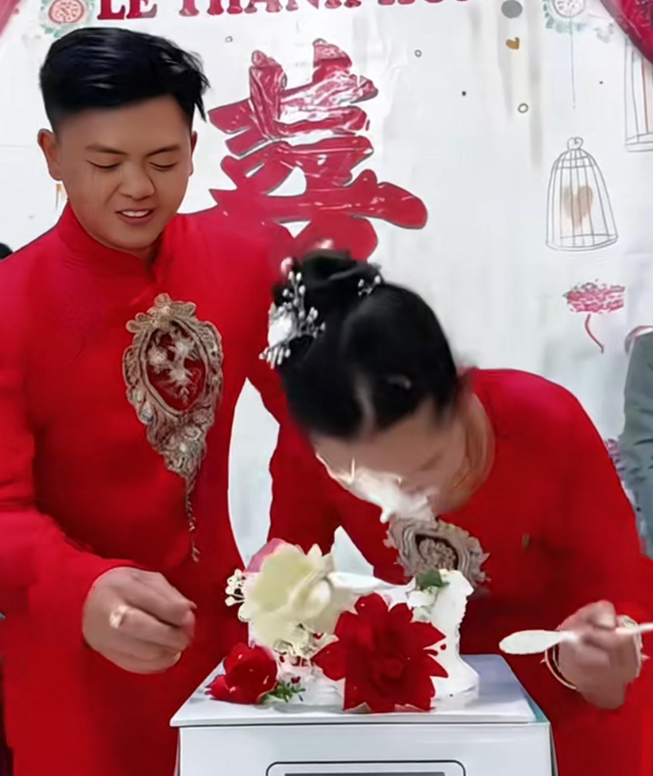 新郎在婚宴上捉弄新娘，新娘认真看自己的结婚蛋糕的时候，新郎一把把新娘的头往下推，