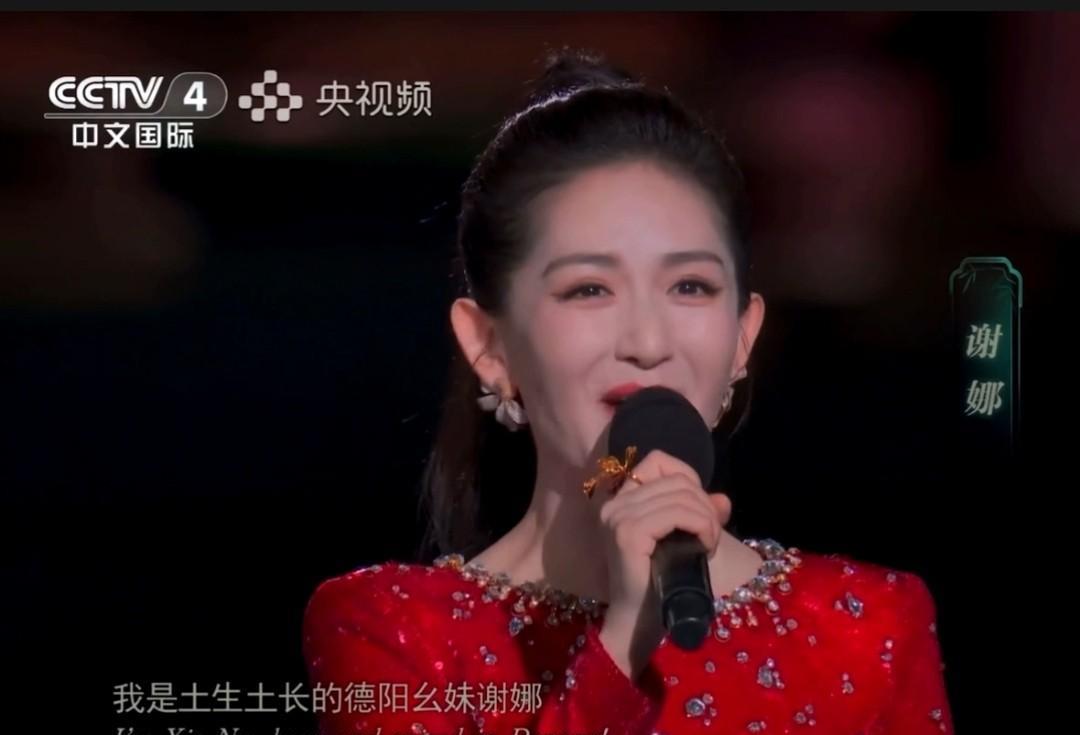 谢娜，央视主持中秋晚会的图片。她穿上了一袭大红长裙，与节日的气氛相呼应。当她