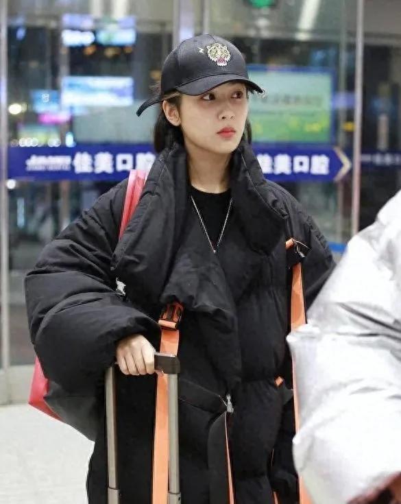 杨紫这机场穿搭也太会了！黑羽绒服配红运动裤，撞色拿捏得刚好，棒球帽一戴，又