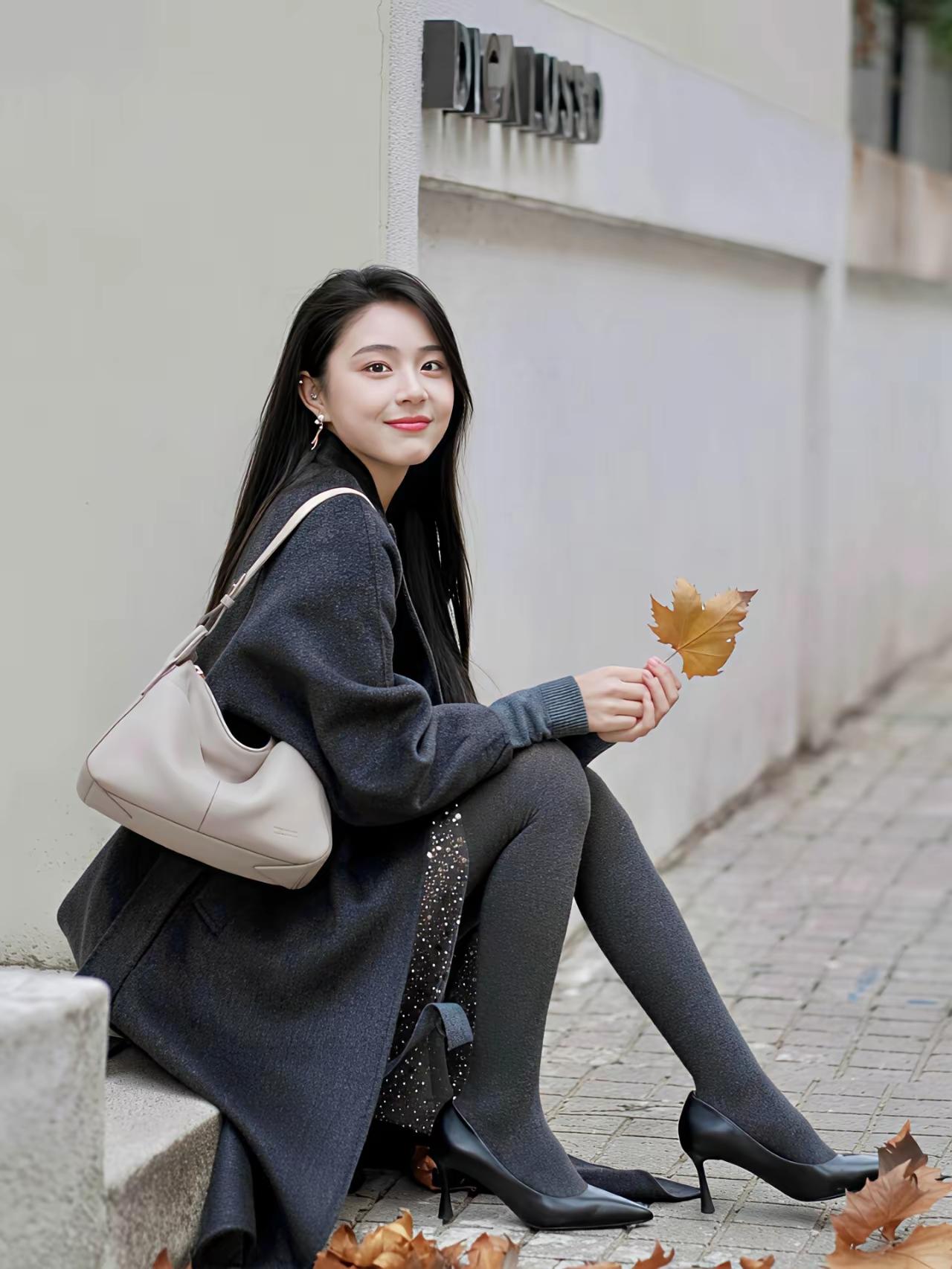 秋末冬初穿搭，身着深灰长款毛呢大衣，搭配闪钻内搭、灰闪连裤袜与黑高跟鞋，米色包包