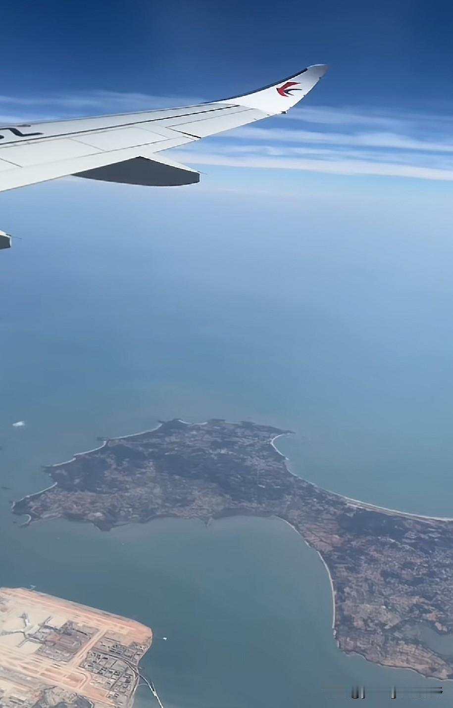 飞机从厦门的上空飞过，下面是正在建设的翔安国际机场，旁边的岛屿就是金门岛。高空视