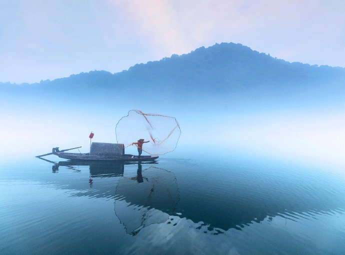 湖南·小东江，云雾萦绕山间，一叶小舟飘在江面，静如止水，又震撼心灵。