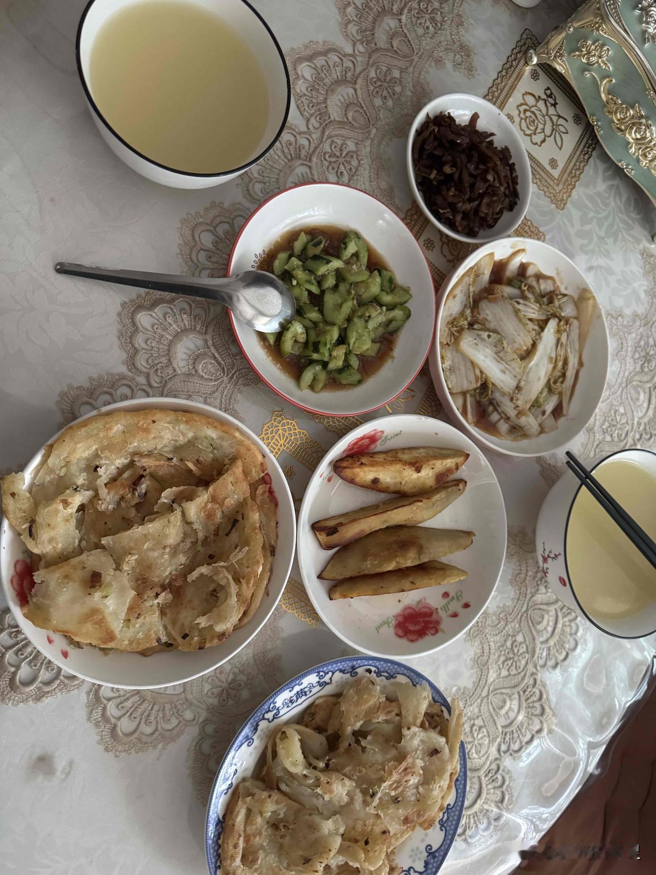看我们今天晚上的家常饭，简简单单。葱花油酥饼。烤红薯。凉拌黄瓜。醋溜白菜