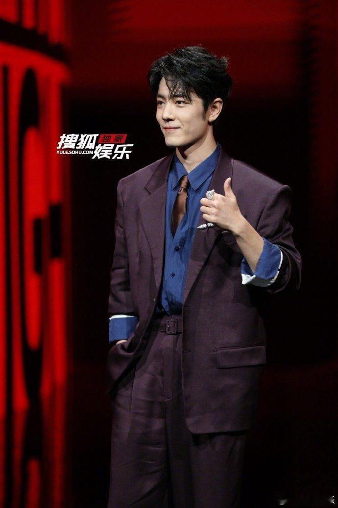 肖战红毯大屏好红肖战红毯现场大屏肖战红毯现场大屏，深紫西装搭配蓝衬衫，焦糖领带设