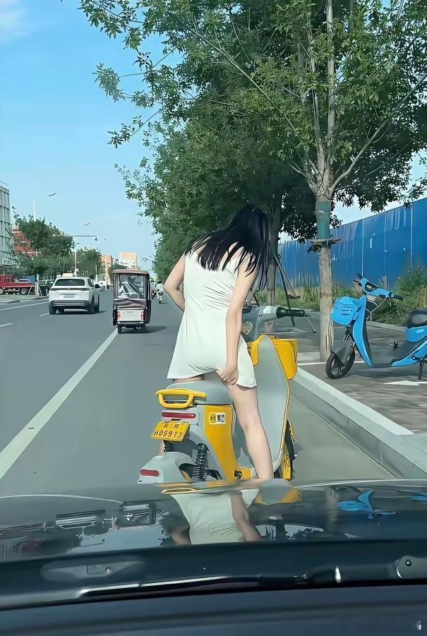 骑车时，裙摆飘飘虽美却添烦恼。风起时，需时刻留意，优雅与不便并存。或许，骑行与裙
