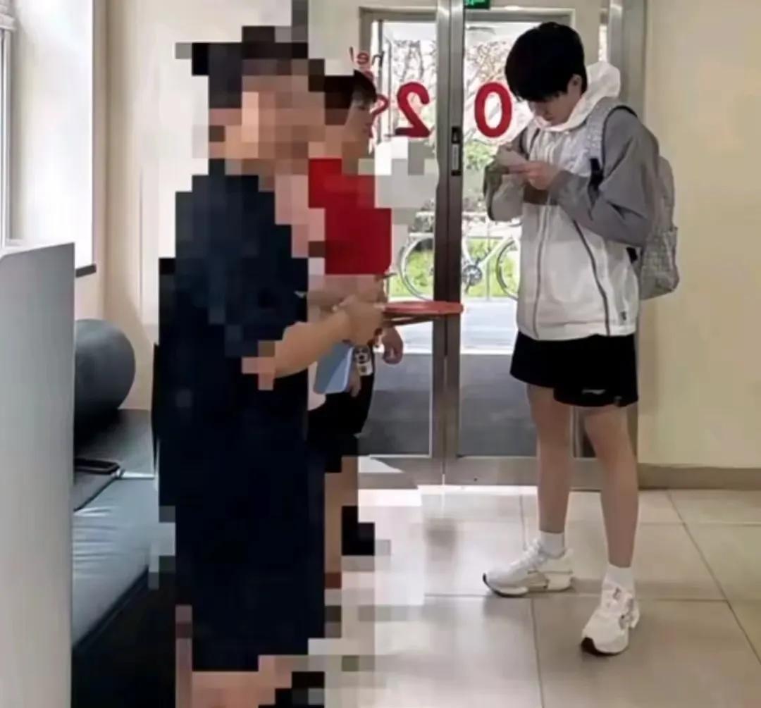 背着双肩包的王楚钦像个青春大男孩乖乖的给等在体总公寓楼门口的球迷签名大