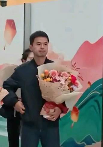 蓉城助教甘锐手捧鲜花，陪副总姚夏到天府机场接机，可能是俱乐部派出，至少也经过俱乐