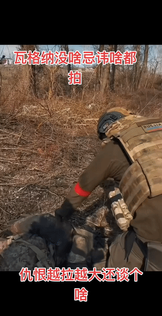 一名俄罗斯“瓦格纳”雇佣兵从一名已经阵亡的敌军士兵遗体上撕下了他军服上的臂章。