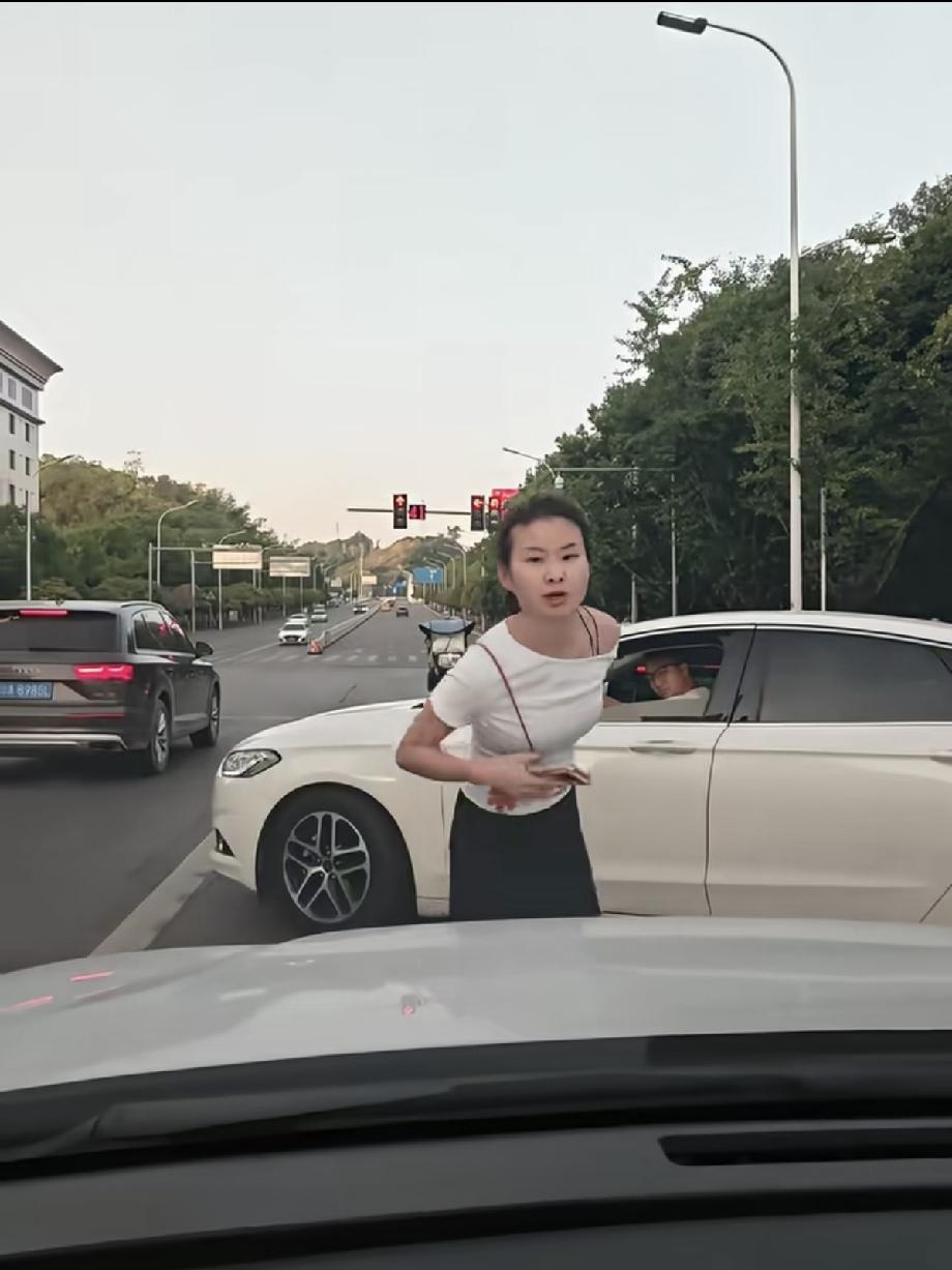 太嚣张了，重庆，晚高峰堵车，一白衣女子直接从副驾驶下来站在车头拦路，指挥自家车强