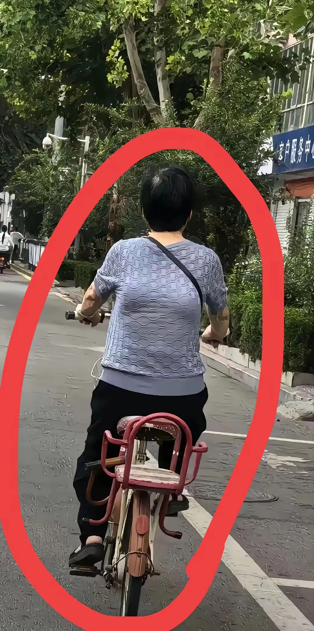 马路上，突然发现前面一名穿蓝色短袖的女子，骑着自行车，万万没想到：仔细看女子的衣