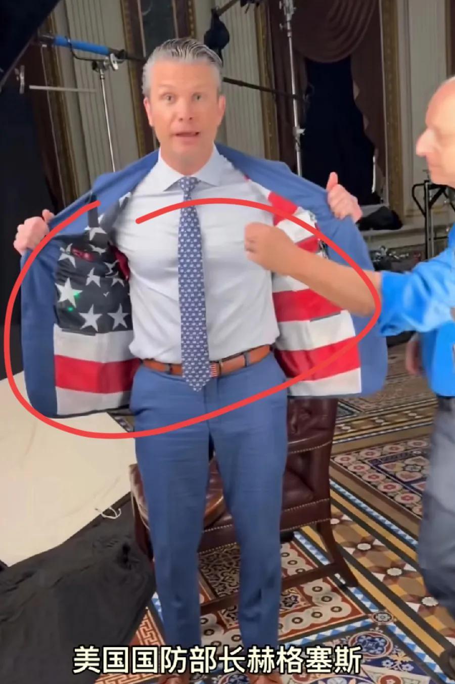赫格塞斯，向记者展示自己的衣服穿着，全身上下，一身美国国旗图案！西服胸前口袋、裤