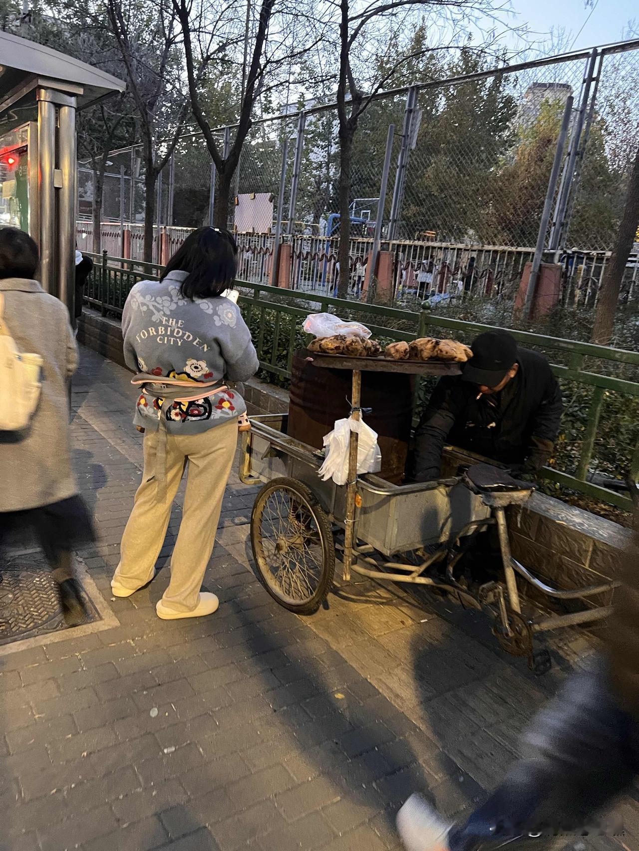 冬天来了，久违的烤红薯又出现在街头巷尾。一辆三轮车，一个汽油桶，桶上摆着一圈烤好