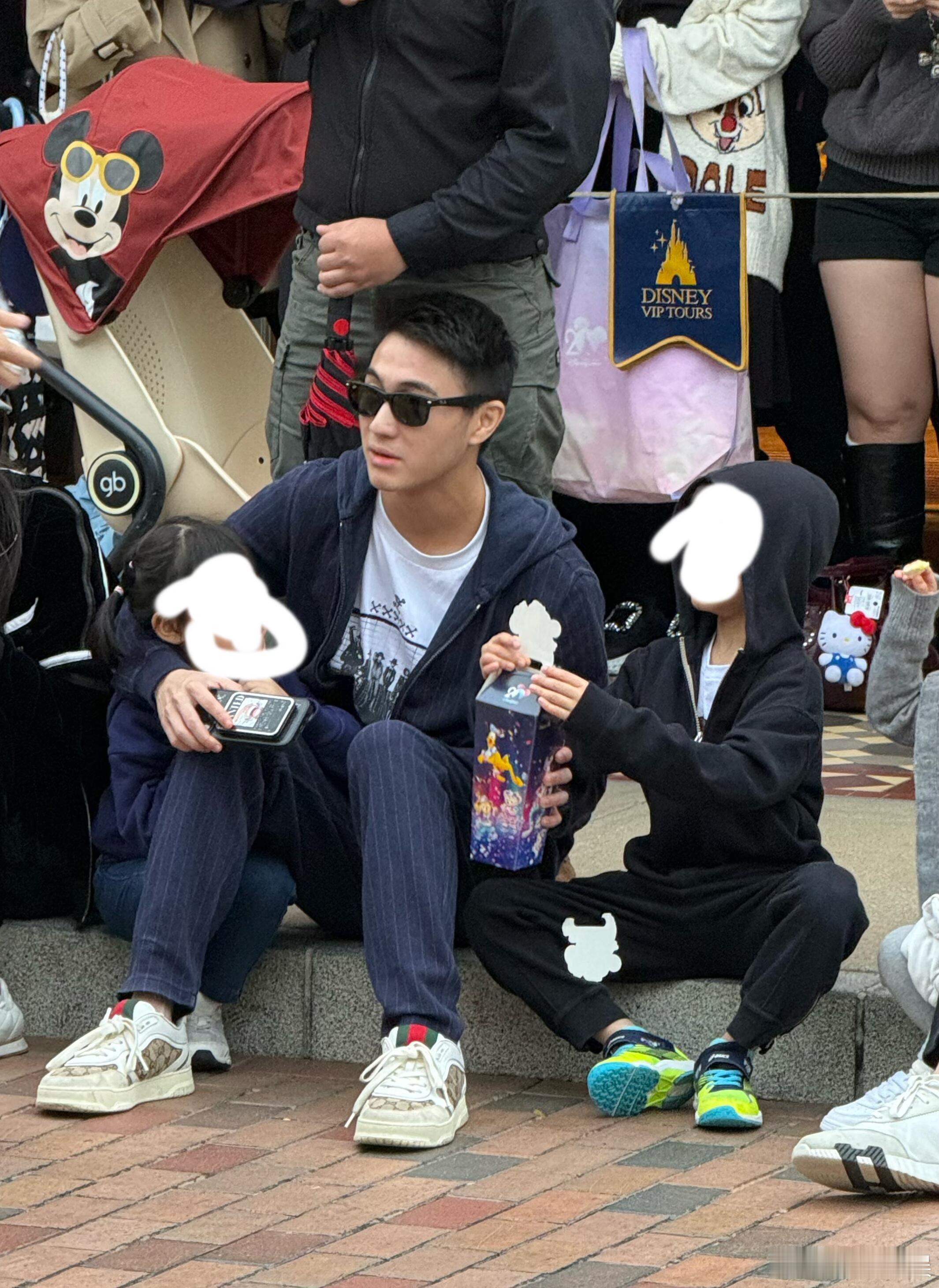何猷君带儿女游玩迪士尼何猷君和儿女坐路边看花车巡游何猷君带儿女游玩迪士尼，好可
