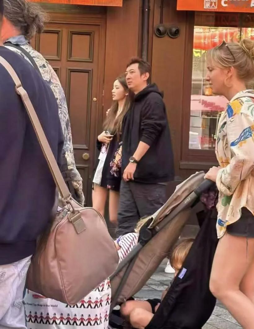 38岁王思聪和网红女友懒懒在伦敦唐人街被偶遇，两人边走边逛，他将手搭在女友的肩膀