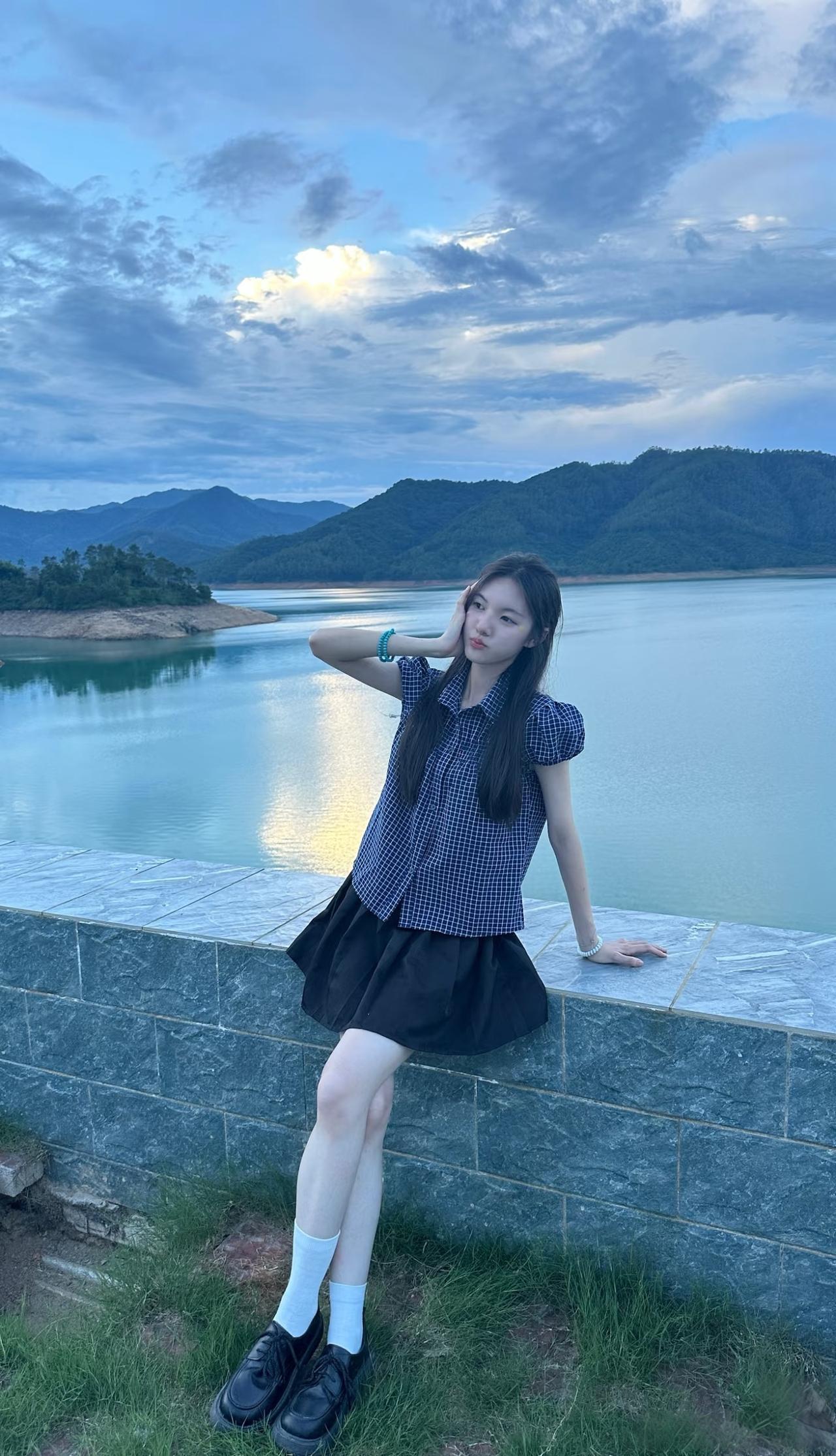少女在湖边轻倚栏杆，看蓝天白云