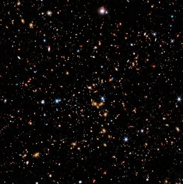 在图像中，我们看到的是各种形状和颜色的星系，有的圆润、有的螺旋，越遥远的星系颜色