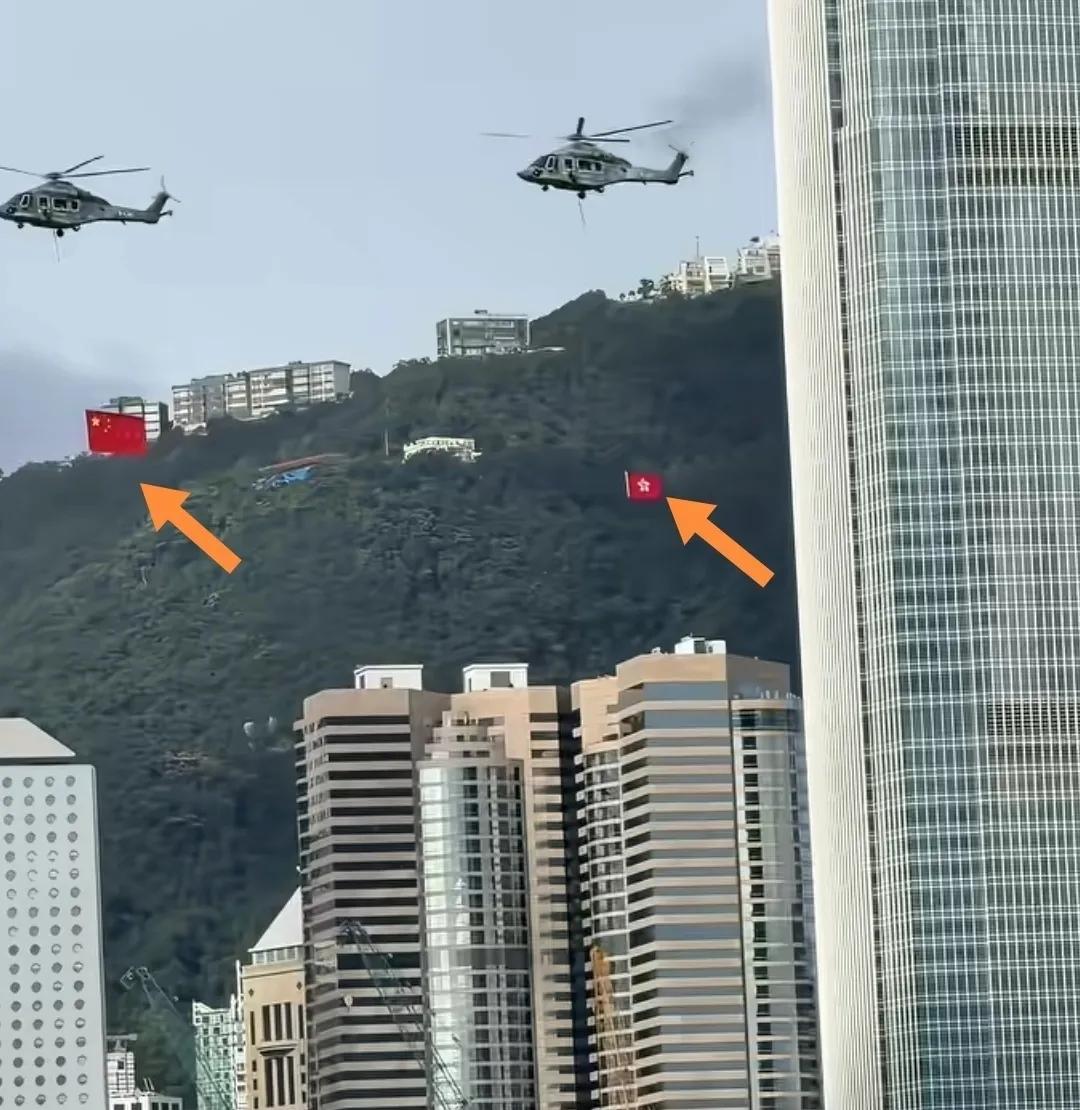 7月1日，香港城市上空五星红旗和五星紫荆花区旗一前一后随风飞行招展。