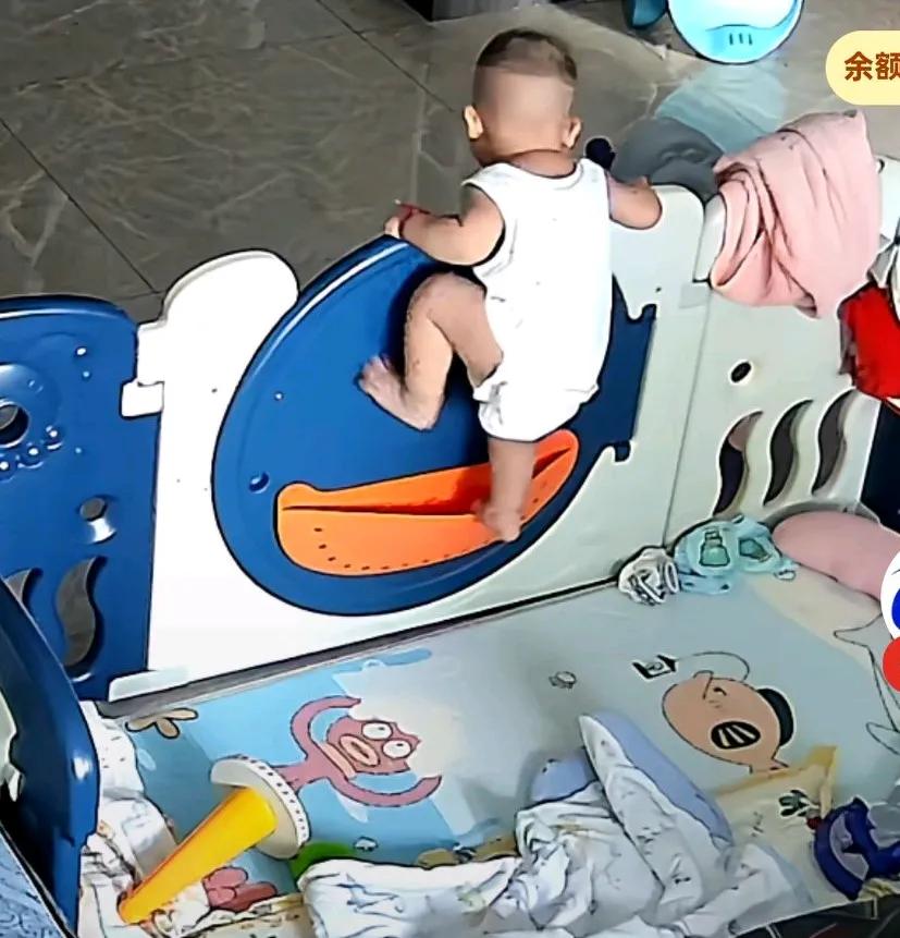 妈妈去送大宝上学，二宝醒来看不到妈妈，爬到围栏上，出不去也下不来，在那哇哇大哭