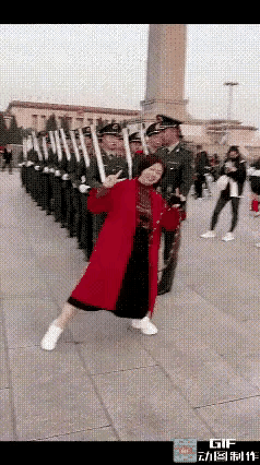 红衣大妈来到广场上看升旗，兵哥哥们列队整装待发，大妈突然走了上去，挡在了兵哥哥的