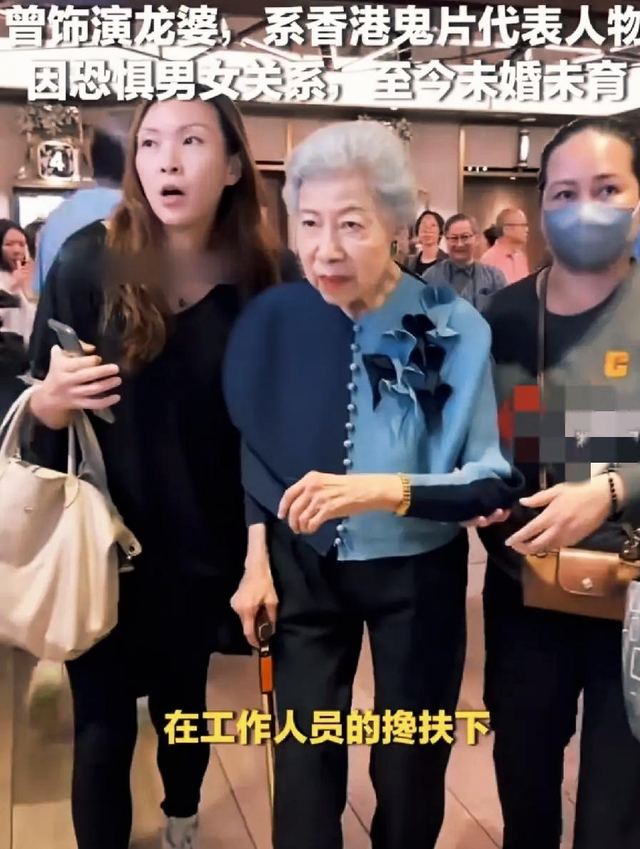 91岁的“龙婆”罗兰被TVB从官网艺人名单除名，近日现身活动被搀扶上台的画面看得