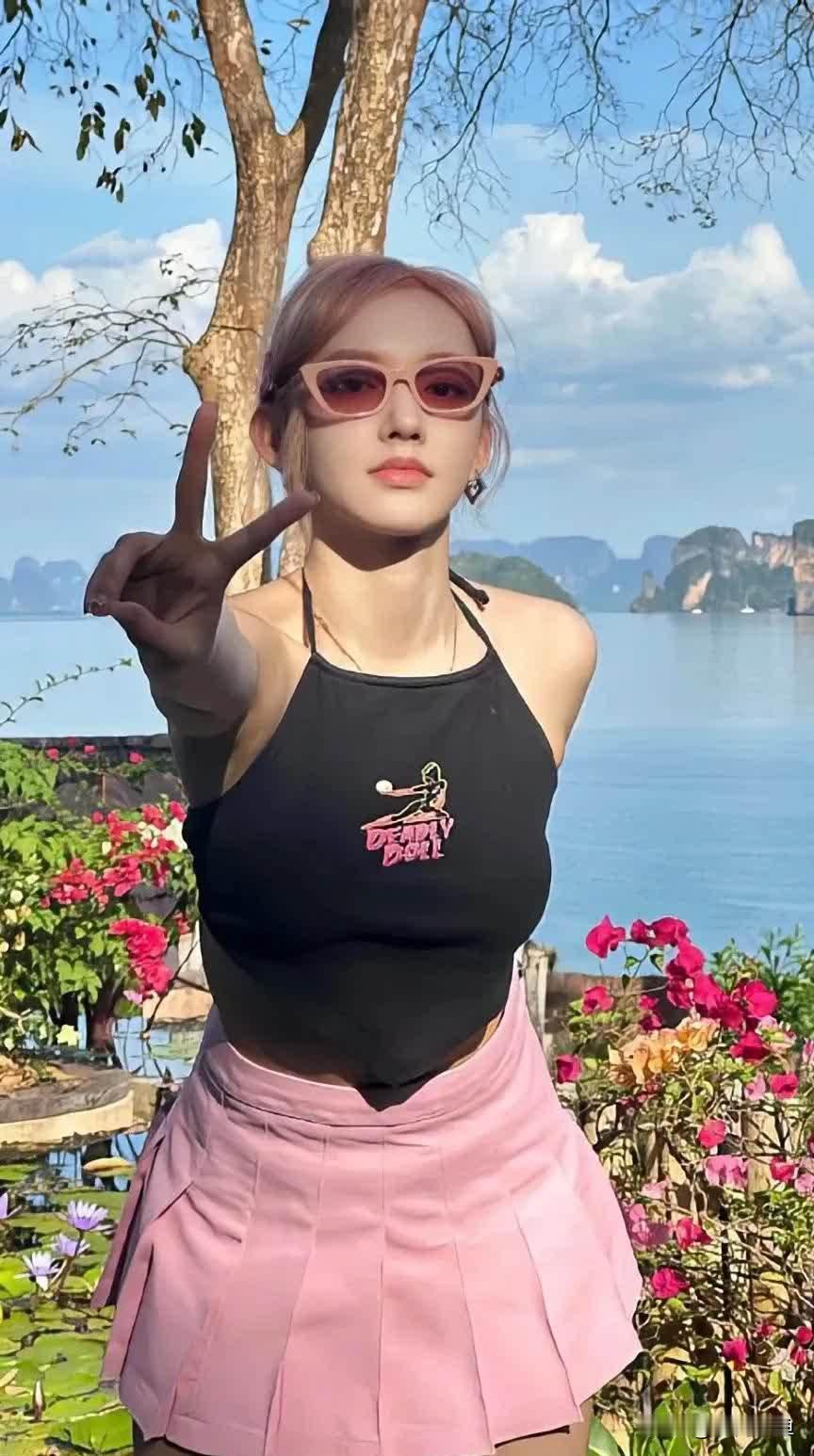 程潇海边度假粉发甜辣！一身黑色挂脖小吊带，露背设计勾勒流畅背部线条，下身搭配
