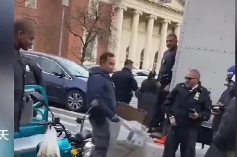 华人开着三蹦子在纽约街头收集废纸壳被美国警察拦停，一名黑人警察弯腰摆弄了半天，也
