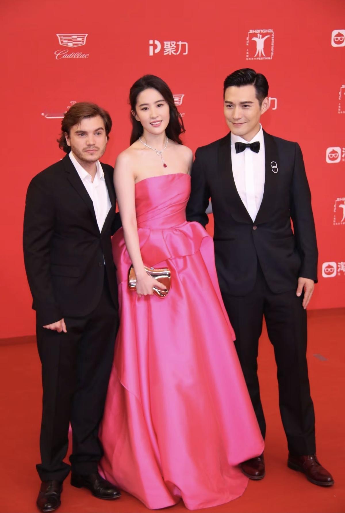 玫红炽热似霞，抹胸设计勾勒玲珑肩颈，长裙曳地自带风华，刘亦菲站在那里，便如古典仕