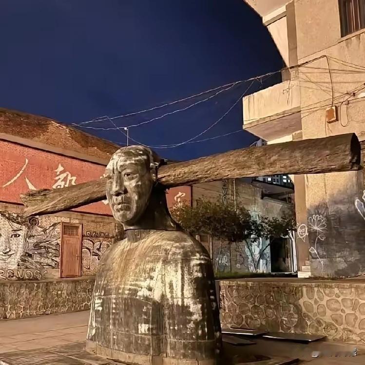 这个雕像雕的奇葩，雕像的脑袋上穿着一根横术，也不知道这是想表达什么样的艺术内涵，