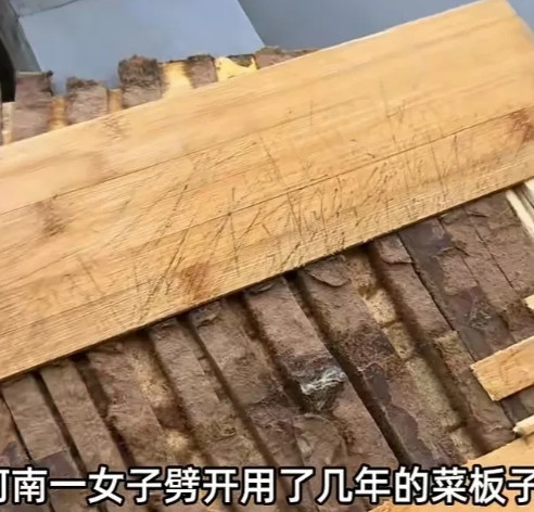 一女子把使用多年的菜板劈开后，看到里面的情形时，不由得惊呆了，吓得赶紧扔掉了。