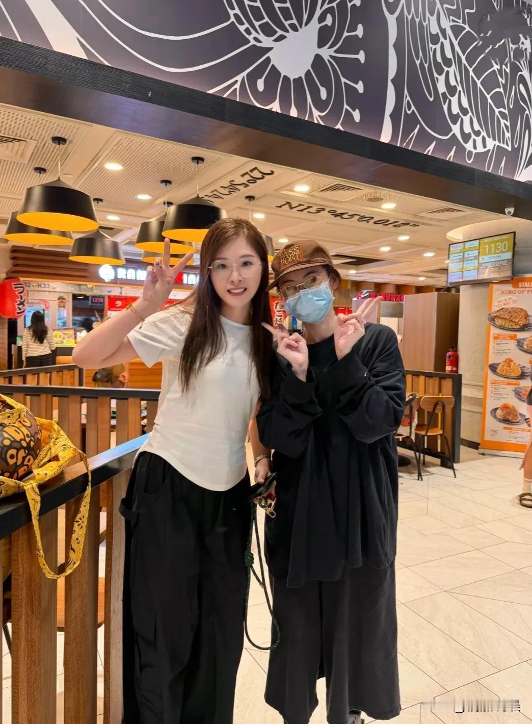 张柏芝现身新加坡樟宜机场。她穿着一身宽松的黑色服装，戴着眼镜，还戴着口罩，肤色