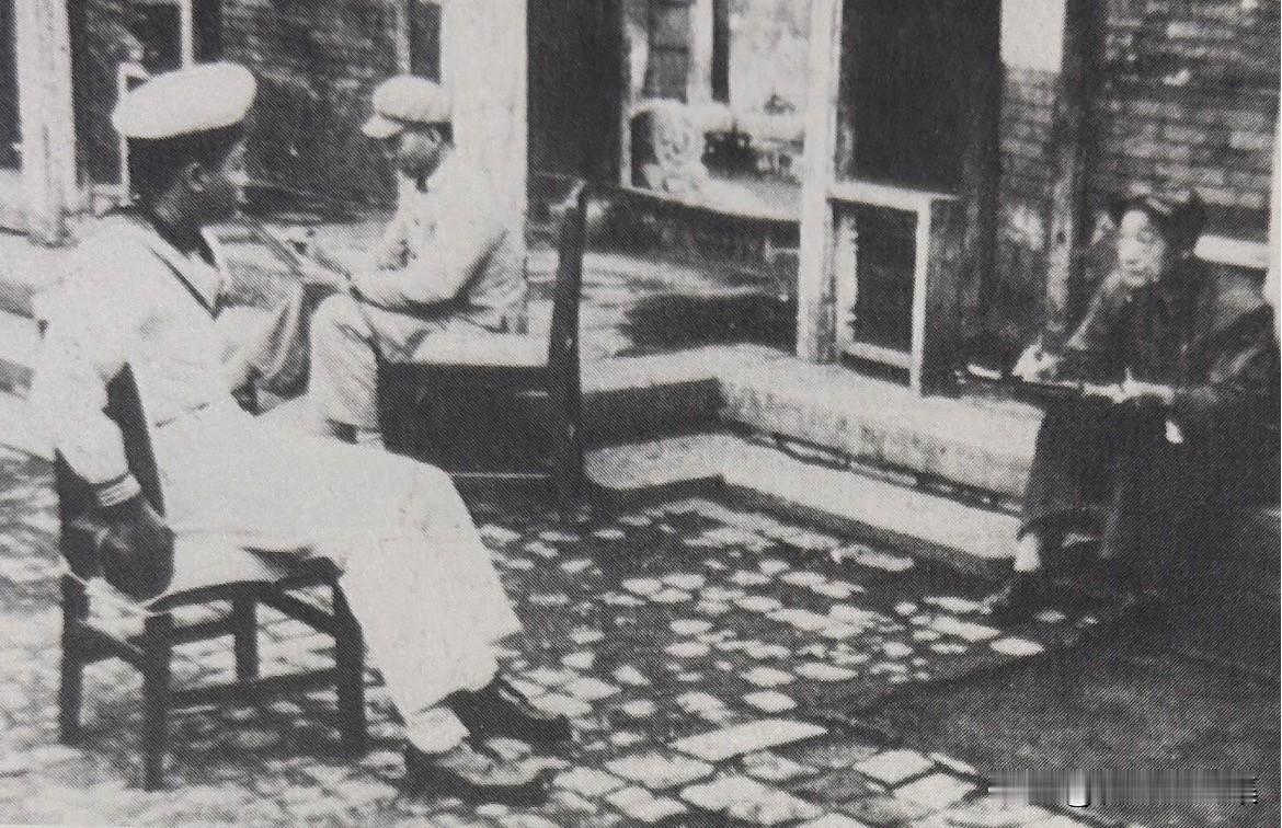1950年，徐悲鸿为解放军海军战士画像。海军战士坐在靠背椅上，徐悲鸿则坐在低低的
