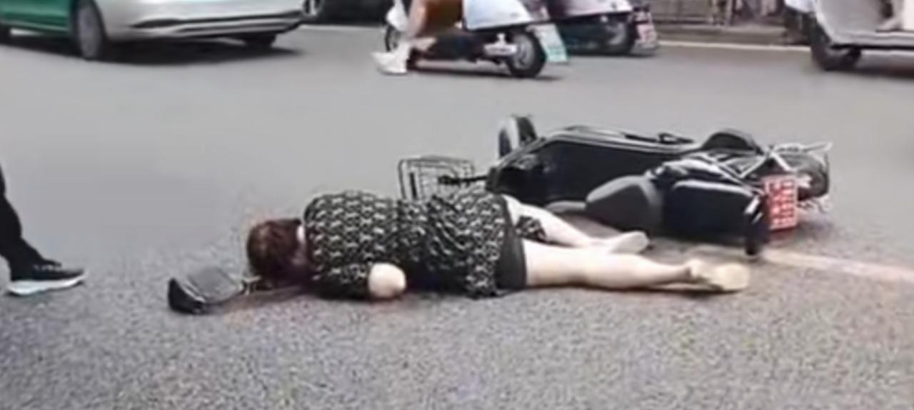 女子摔倒没人敢扶，电动车在一边吱吱地叫。一个社会到了如此寒心的地步？始作俑者难