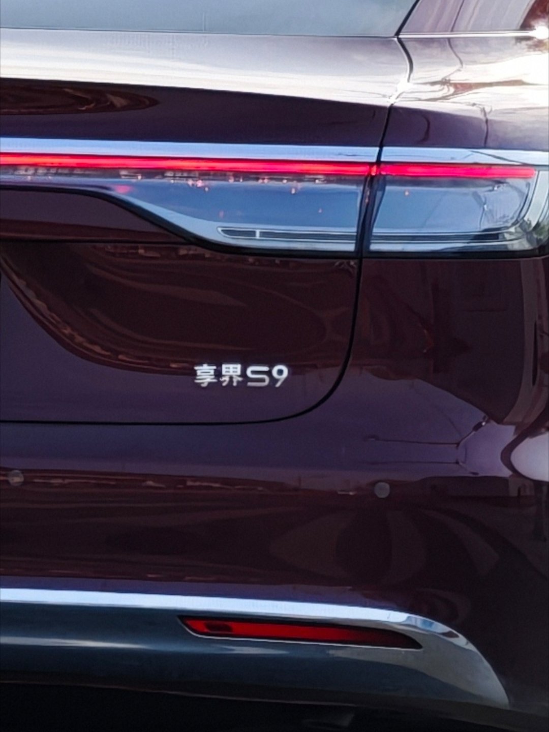 享界S9这个角度很好看酒红色车身+密条幅轮圈，相当优雅贵气~但是尾标这个“S”，
