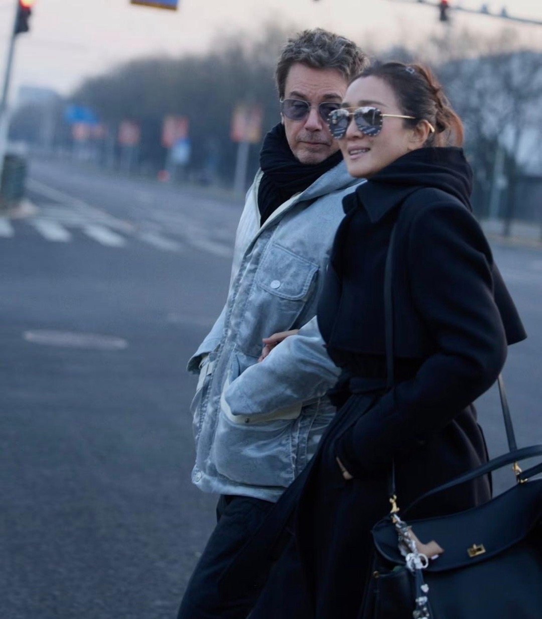 59岁巩俐与77岁老公米歇尔现身北京中轴线！两人手挽手甜蜜同行，恩爱模样宛如小情