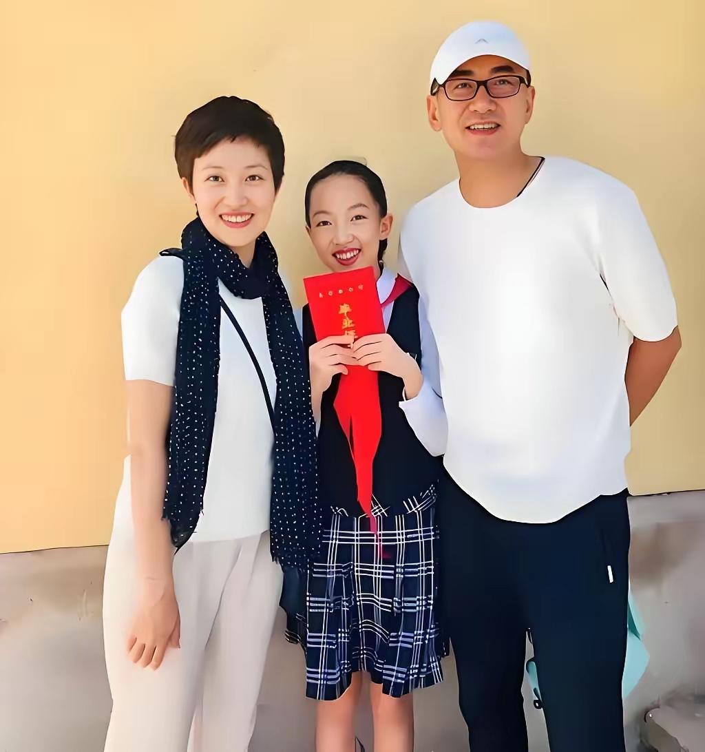央视主持人鲁健、郑天亮夫妇和女儿的家庭合影，照片里，女儿拿着小学毕业证书，一起和