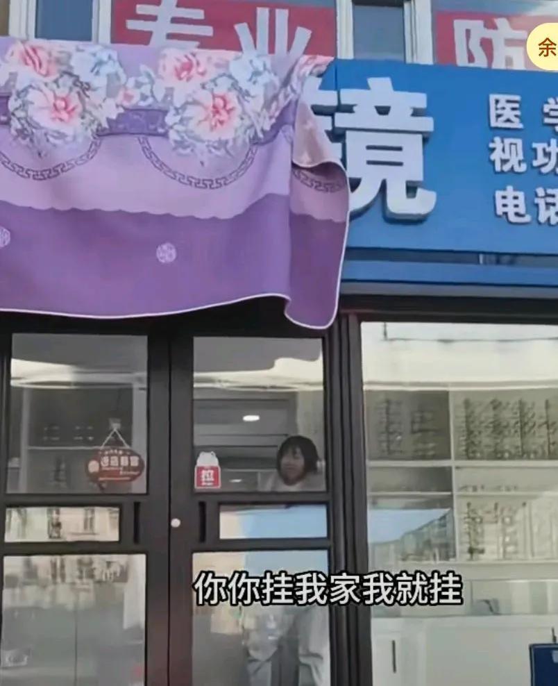 一楼的牌匾挡住了男子家采光，男子用床单将其盖住，一楼人员出来说谁盖的男子说就是